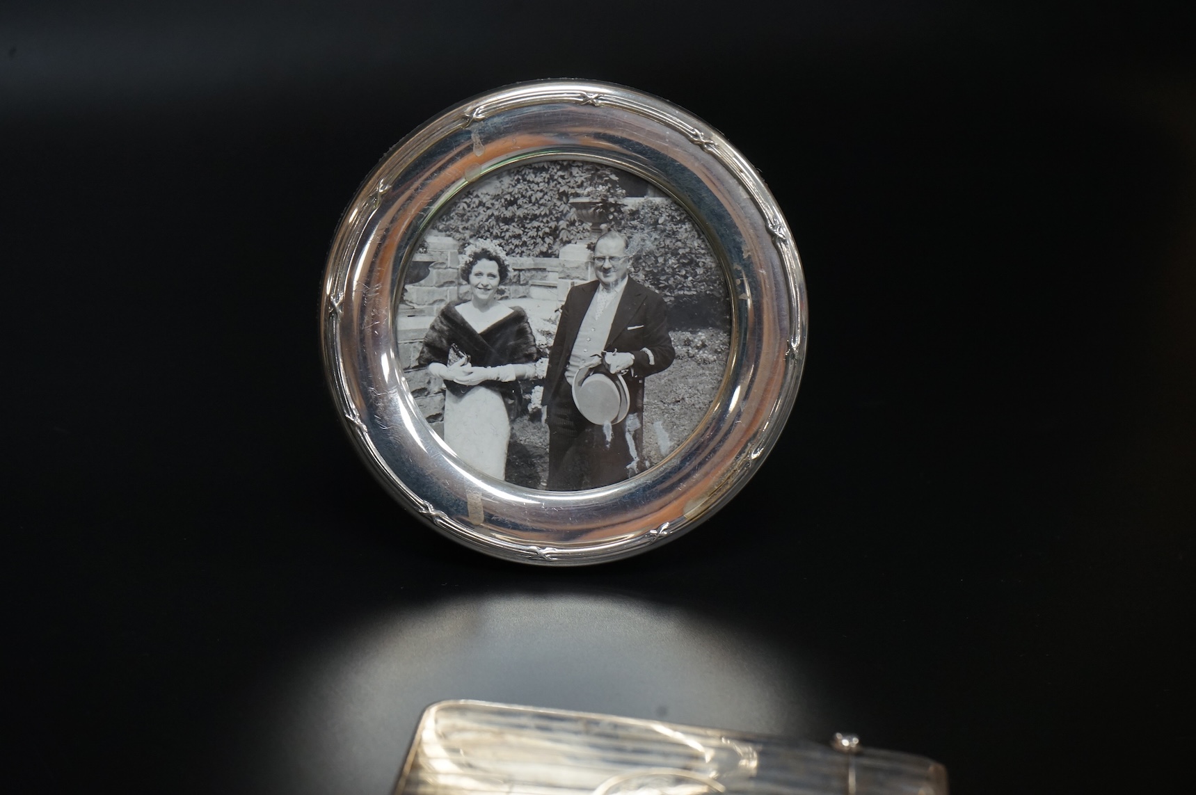 A George V silver rectangular card case by William Henry Sparrow, Birmingham, 1913, 89mm, a modern silver mounted circular photograph frame and five other items including a three piece silver plate and enamel mirror and